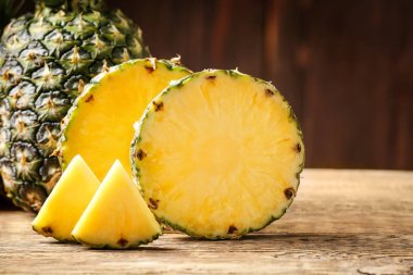 Ahşap masa üzerinde tüm ve kesme olgun ananas