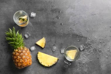 Taze ananas ve gri arka plan üzerinde su bardak düz yatıyordu kompozisyonu