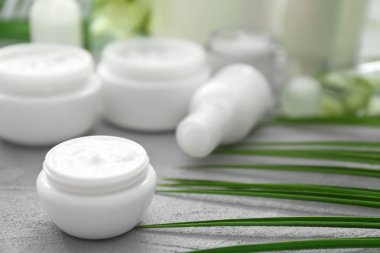 Gri arka plan üzerinde bitkisel özü ile krem kavanoz