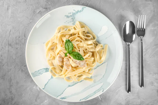 Assiette de pâtes savoureuses avec filet de poulet sur la table, vue sur le dessus — Photo