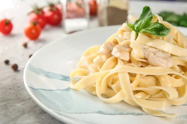 Piatto di pasta saporita con filetto di pollo sul tavolo, primo piano — Foto Stock