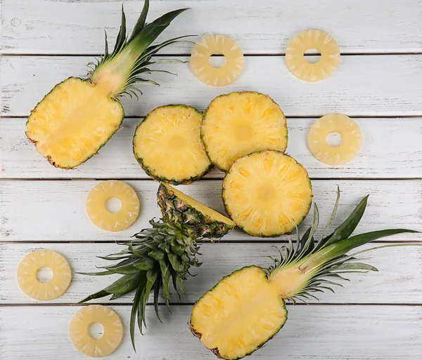 Sammansättning med skivad ananas på trä bakgrund — Stockfoto