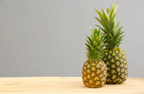 Piñas frescas maduras sobre mesa sobre fondo gris — Foto de Stock