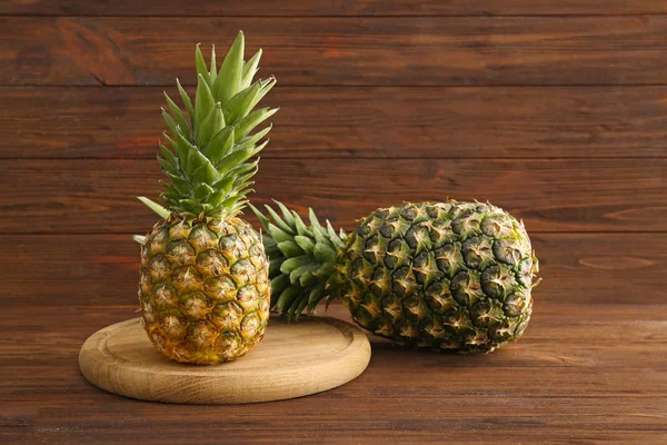 Świeże, dojrzałe ananasy na podłoże drewniane — Zdjęcie stockowe