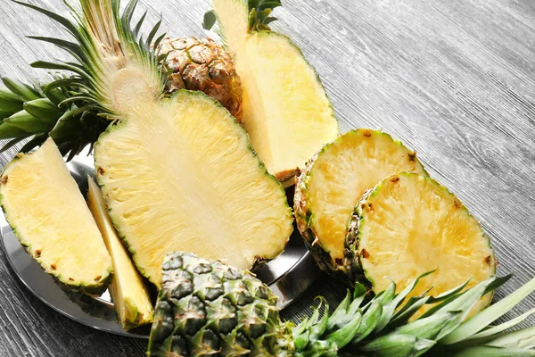 Cut ripe pineapples on wooden background — Stock Photo, Image