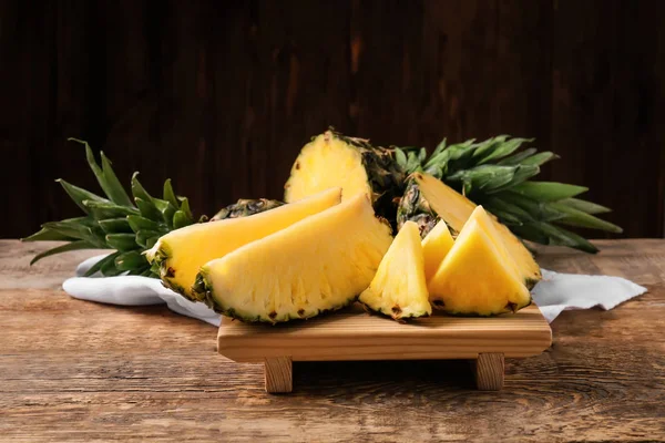 Board with cut ripe pineapple on wooden table — Stock Photo, Image