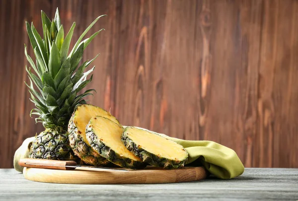 Tabla con piña madura cortada sobre mesa de madera —  Fotos de Stock