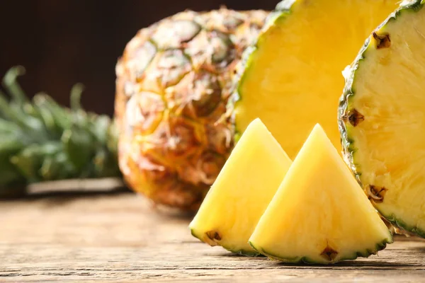 Cut ripe pineapples on wooden table, closeup — Stock Photo, Image