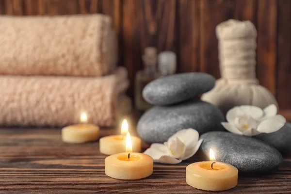 Velas e pedras de spa para tratamento de spa em mesa de madeira — Fotografia de Stock