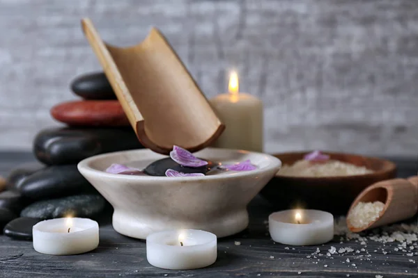 Spa composition with water in bowl and candles on table — Stock Photo, Image