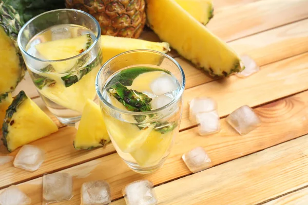 Glasses of water with fresh sliced pineapple on table — Stock Photo, Image