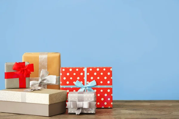 Hermosas cajas de regalo en la mesa contra el fondo de color — Foto de Stock