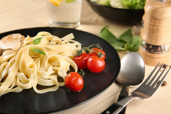 Plate of delicious pasta with tomatoes on table, closeup — Stock Photo, Image