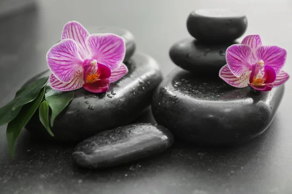 Spa taşlar ve masaya güzel orkide çiçek — Stok fotoğraf