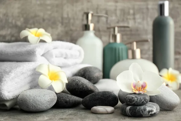 Hermosa composición de spa con piedras y flores en la mesa —  Fotos de Stock