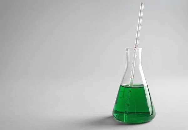 Test flask with color sample on light background — Stock Photo, Image