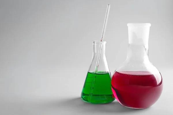 Vetreria chimica con campioni colorati su sfondo chiaro — Foto Stock