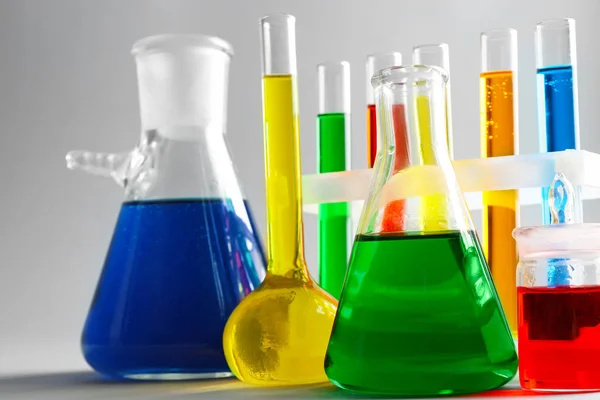 Vetreria chimica con campioni colorati su sfondo chiaro — Foto Stock
