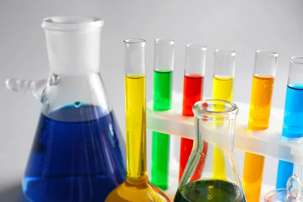 Chemiegläser mit bunten Proben auf hellem Hintergrund, Nahaufnahme — Stockfoto
