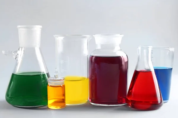 Chemical glassware with samples on light background — Stock Photo, Image