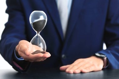 Adam holding kum saati tablo üzerinde. Zaman yönetimi kavramı