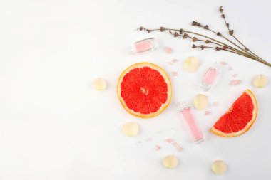 Esans ve beyaz zemin üzerine Dilimlenmiş Greyfurt şişe ile bileşimi. Doğal kozmetik