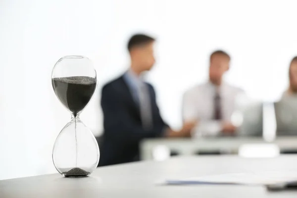 Hourglass and blurred people on background. Time management concept — Stock Photo, Image