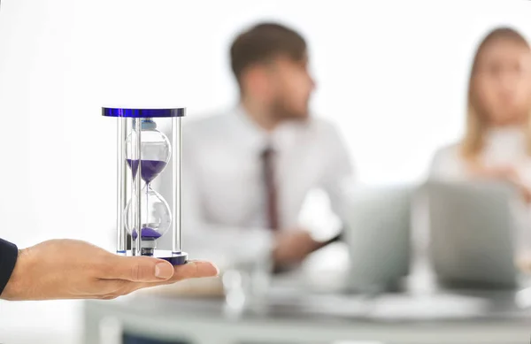Man holding hourglass and blurred people on background. Time management concept — Stock Photo, Image