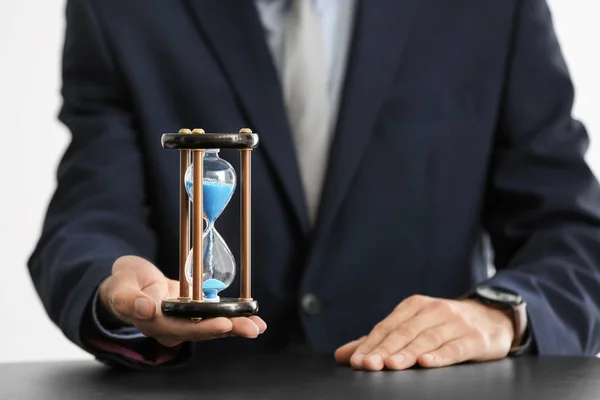 테이블 위에 남자 보유 모래 시계입니다. 시간 관리 개념 — 스톡 사진