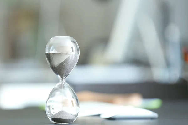 背景をぼかした写真に対してテーブル上に砂時計。時間管理の概念 — ストック写真