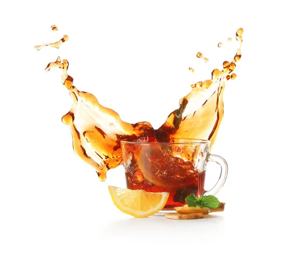 Coupe en verre et éclaboussure de délicieux thé au citron avec du gingembre sur fond blanc — Photo