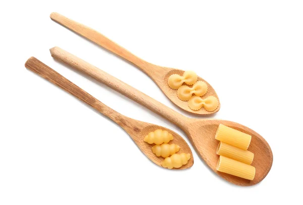 Houten lepels met verschillende soorten pasta op witte achtergrond — Stockfoto