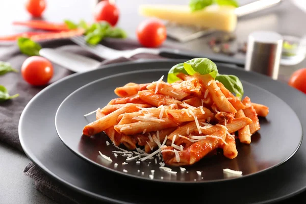 Płyta smaczny makaron z sosem pomidorowym na stole — Zdjęcie stockowe