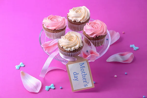 Postre de pie con sabrosos cupcakes en el fondo de color. Celebración del día de la madre — Foto de Stock