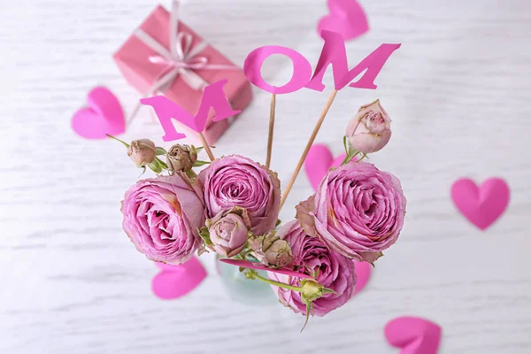Beautiful bouquet with word MOM on table, top view. Mother's day celebration — Stock Photo, Image