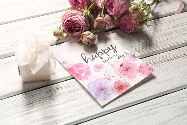 Gift box, flowers and card with words HAPPY MOTHER'S DAY on wooden background — Stock Photo, Image