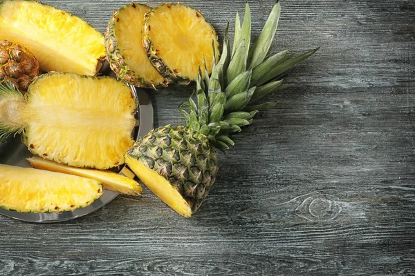 Cut ripe pineapples on wooden background — Stock Photo, Image