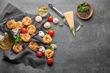 Pişmemiş makarna ve gri arka plan üzerinde ürünleri