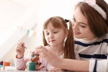 Anne ile kızı masada Paskalya yumurta boyama