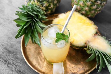Olgun ananas ve bardak taze meyve suyu masada