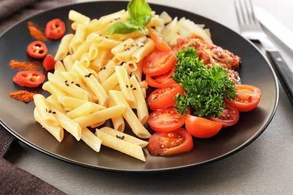 Placa de deliciosa pasta con salsa boloñesa y tomates en la mesa, primer plano — Foto de Stock