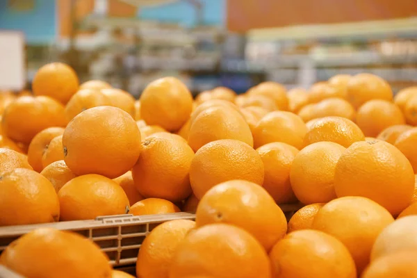 Sok érett narancs műanyag rekeszekben piaci pultra. Citrusfélék — Stock Fotó