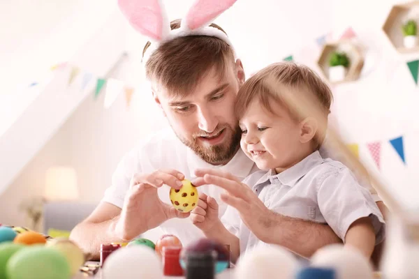 Baba çocuğunu masada Paskalya yumurta boyamak — Stok fotoğraf