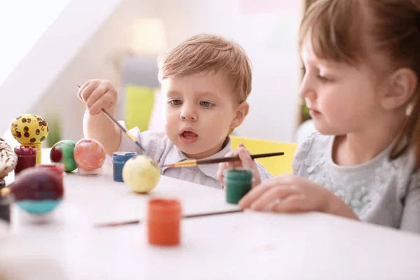 Şirin çocukları Paskalya yumurtaları birlikte masada boyama — Stok fotoğraf