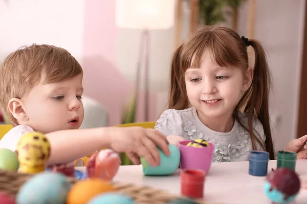 Słodkie dzieci, malowanie pisanek wspólnie przy stole — Zdjęcie stockowe