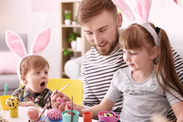 Ojciec z jego dzieci przy stole pisanki — Zdjęcie stockowe