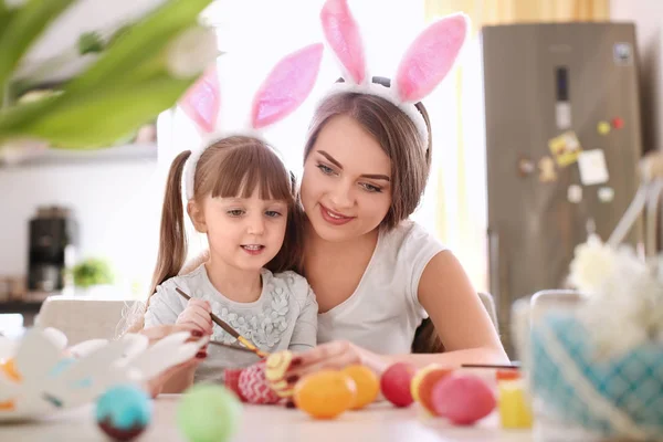 Ζωγραφική αυγά του Πάσχα με το παιδί της στο τραπέζι η μητέρα — Φωτογραφία Αρχείου