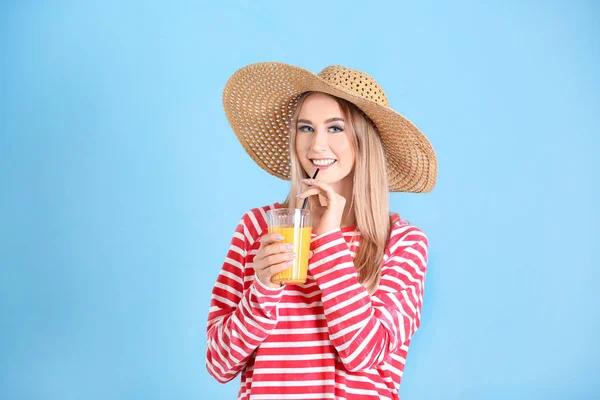 Bella giovane donna che beve succo di agrumi su sfondo di colore — Foto Stock