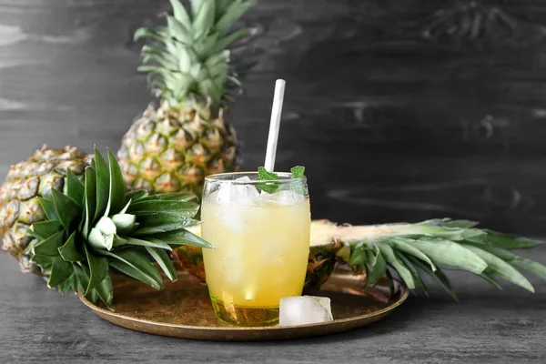 Olgun ananas ve bardak taze meyve suyu masada
