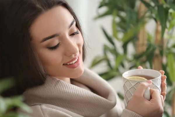 Hermosa joven con taza de té caliente en casa — Foto de Stock